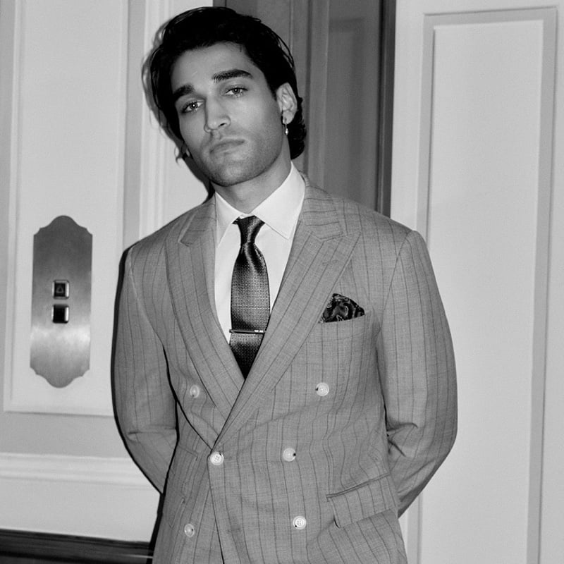 Josh Heuston wears a pinstripe BOSS Made to Order double-breasted suit with a tie and pocket square