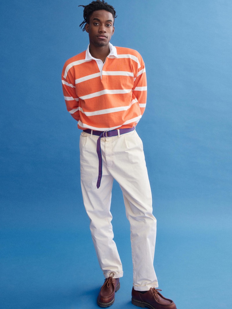 Herzen wears a J.Press x Alex Mill orange and white striped rugby shirt with cream chinos and a purple and orange D-ring belt