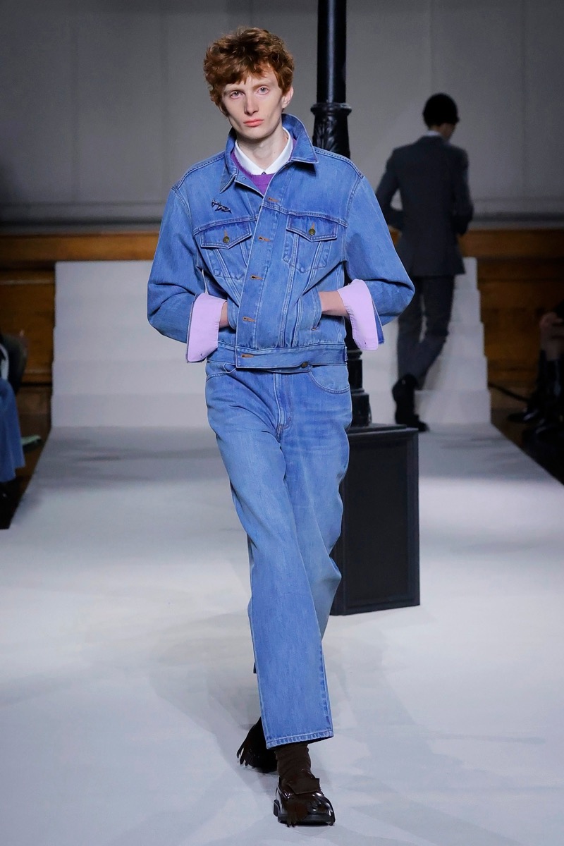 Kent & Curwen fall-winter 2026 denim trucker jacket over straight-leg jeans with lavender knit cuffs at the hem