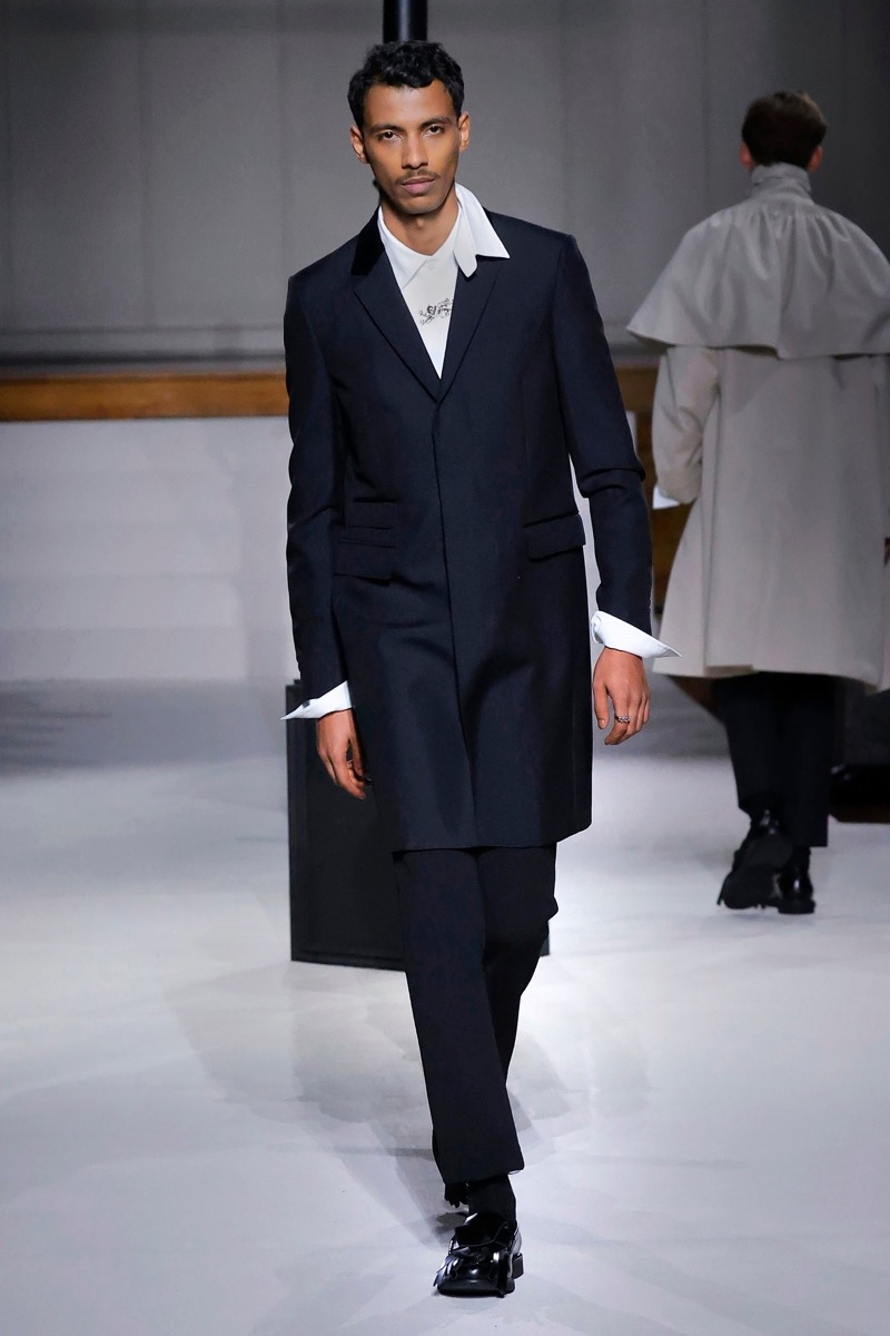 Kent & Curwen fall-winter 2026 navy elongated blazer with wide peak lapels over a white shirt with oversized cuffs and navy trousers
