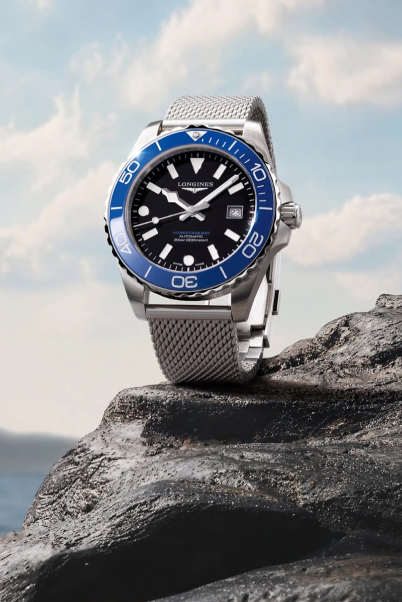 The Longines HydroConquest with a black dial and blue ceramic bezel on a Milanese mesh bracelet