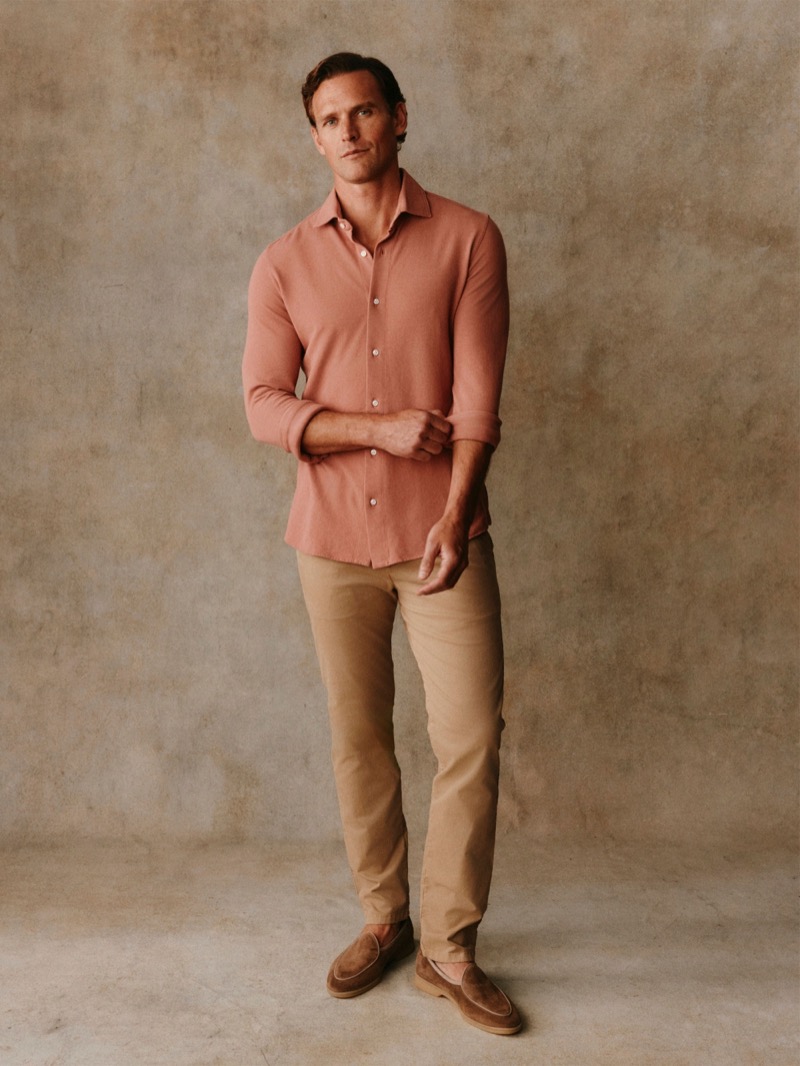 Guy wears a terracotta cotton shirt with tan chinos and brown loafers
