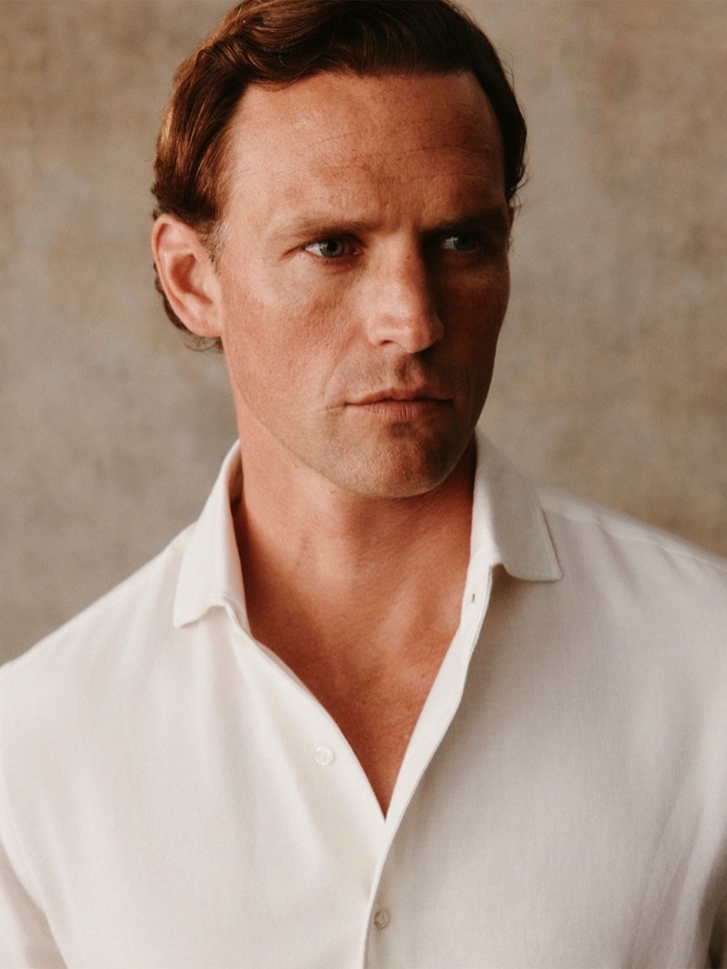 A close-up portrait of Guy in a white linen shirt