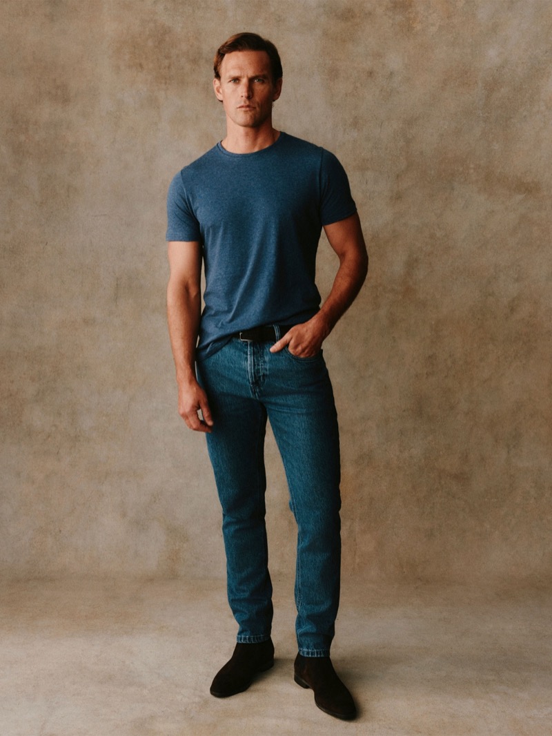 Guy wears a washed blue crewneck t-shirt with blue jeans