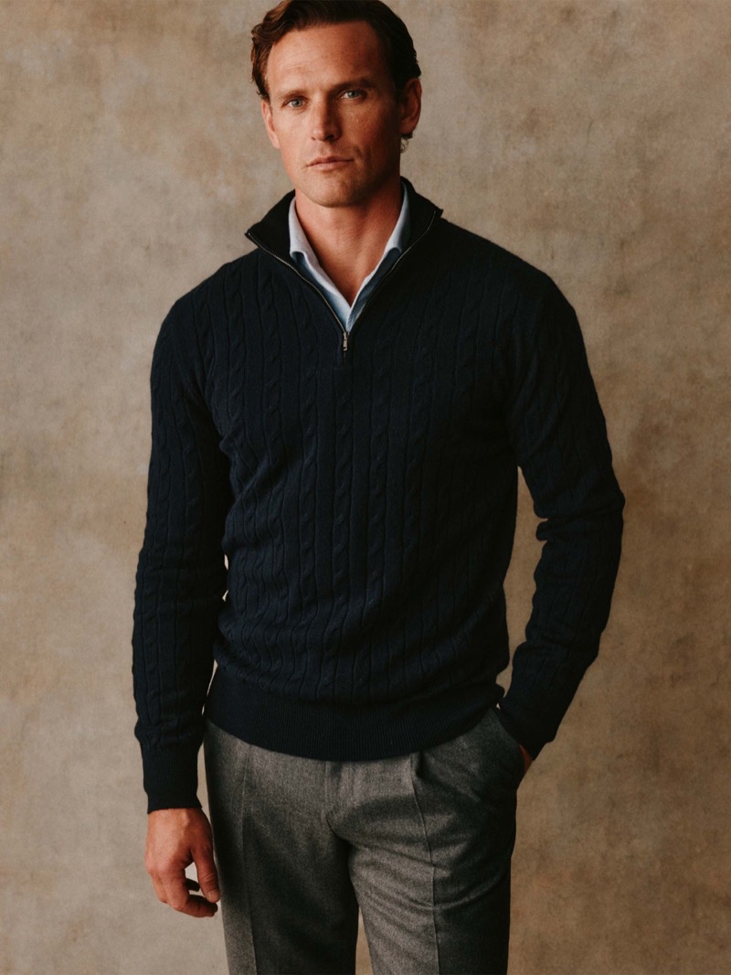 Guy wears a navy cable-knit quarter-zip sweater over a light blue shirt with gray trousers