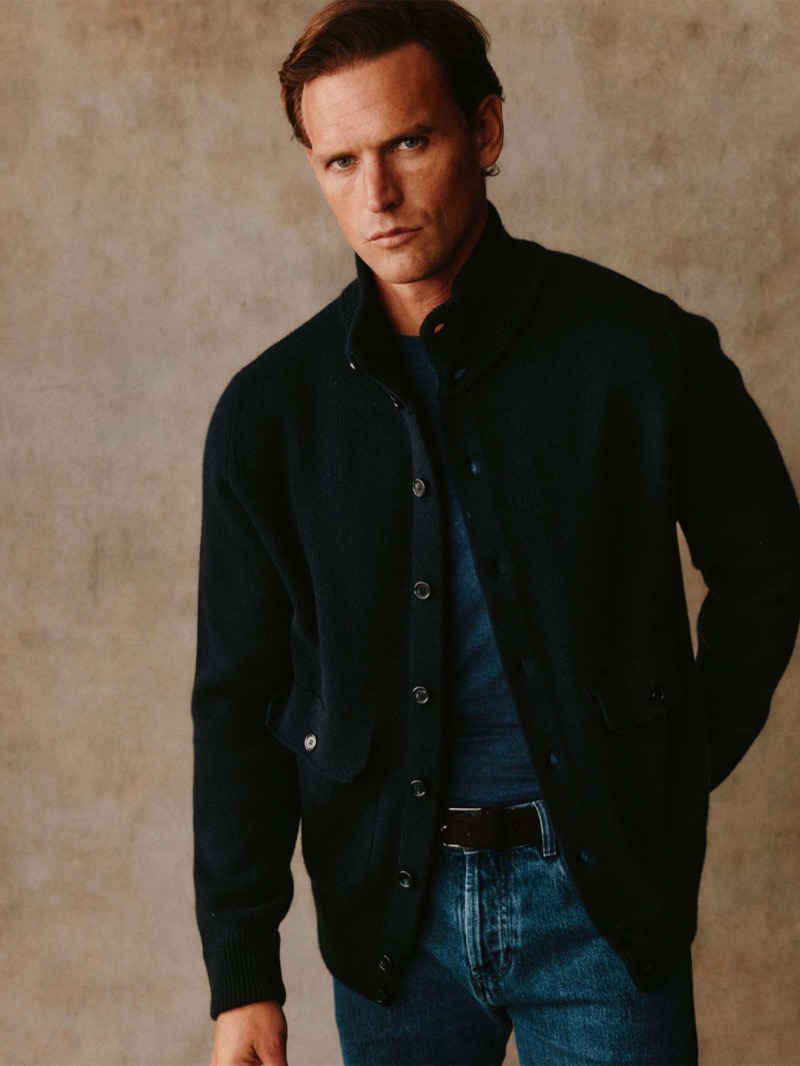Guy wears a navy button-front cardigan over a teal tee with jeans