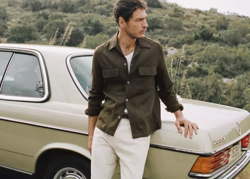 Pierre-Benoit wears a dark overshirt with a bowling collar over a white tee with white trousers
