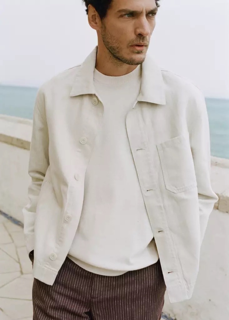 Pierre-Benoit wears a cream jacket over a crew neck with brown pinstripe trousers