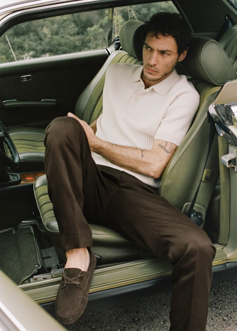 Pierre-Benoit wears a white knit polo with chocolate trousers and suede driving shoes