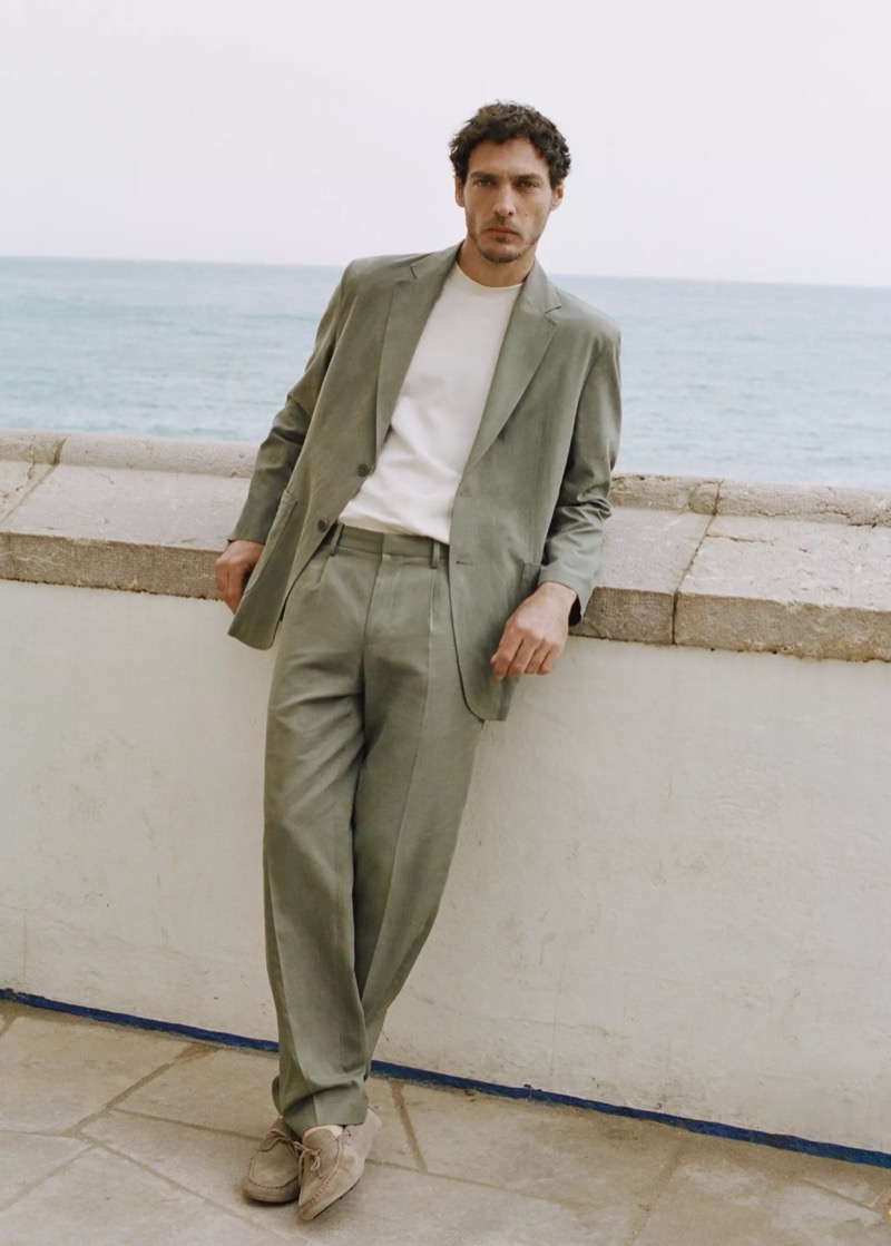 Pierre-Benoit wears a sage green suit over a white crew neck tee with suede shoes