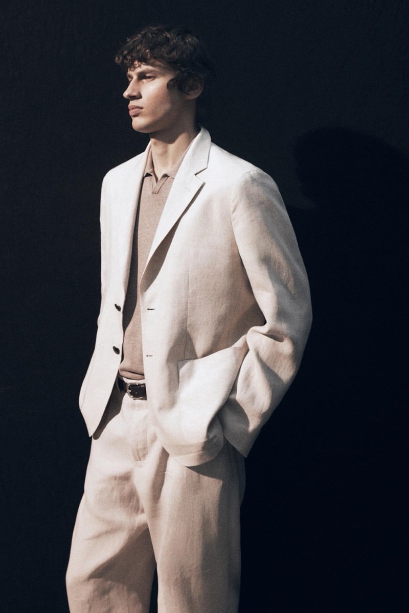 Kaplan wears a cream linen suit over a tan knit polo