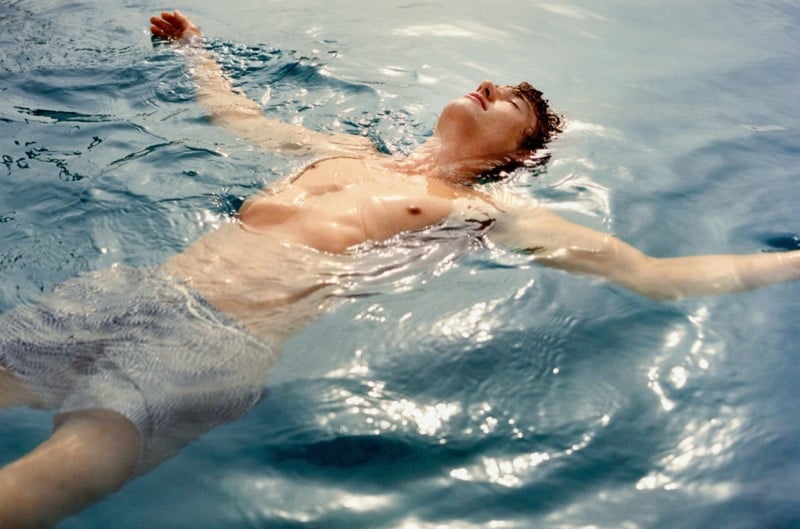 Valentin floats on his back in the Mediterranean Sea wearing Massimo Dutti swim shorts