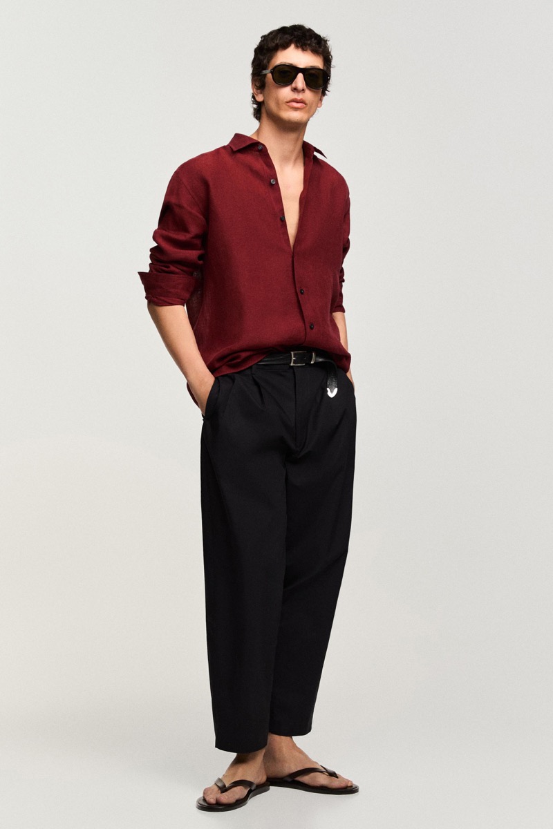 Takfarines wears a burgundy shirt with black trousers and sandals