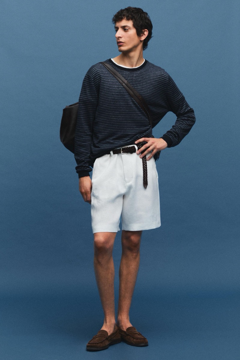 Takfarines wears a navy striped tee with white shorts and a woven belt