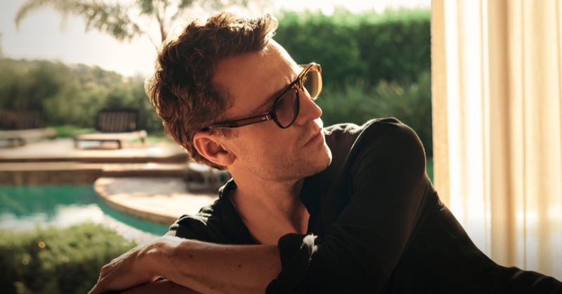George wears Oliver Peoples Paul Newman round amber-tinted sunglasses in profile by the pool