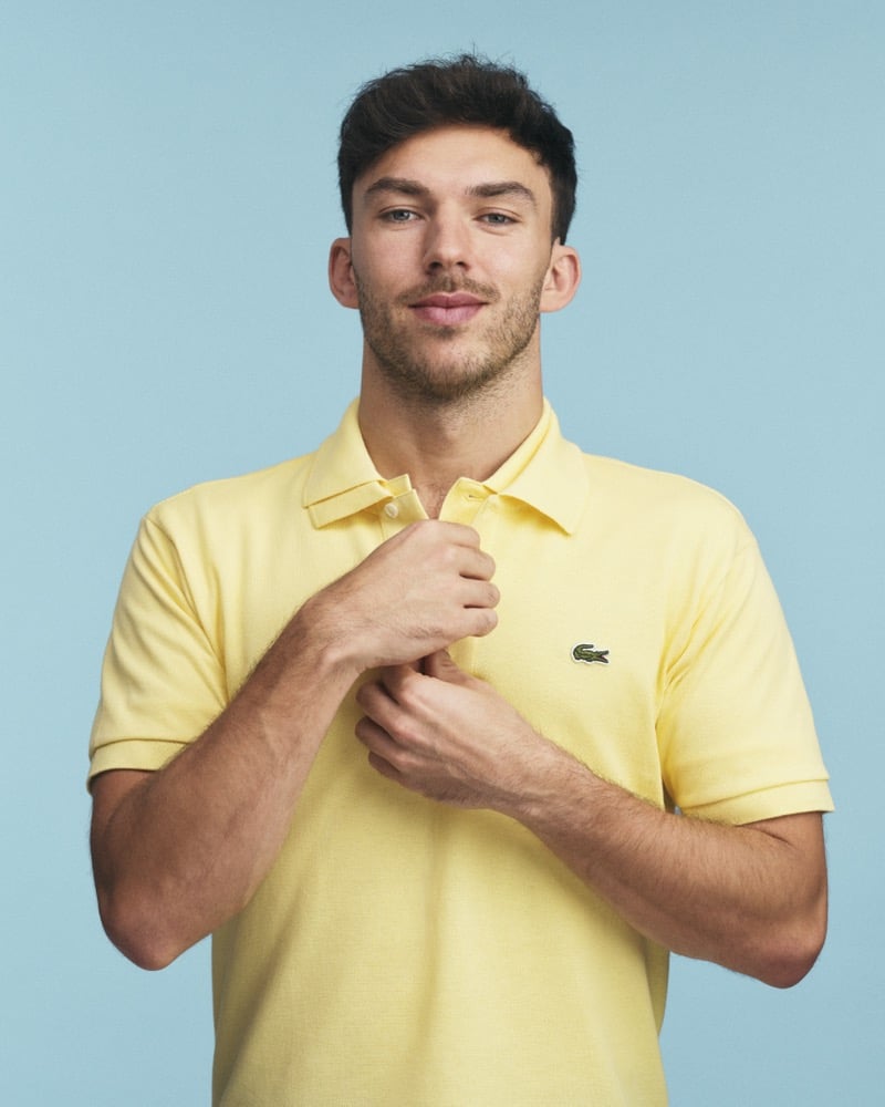 pierre gasly wears a yellow lacoste polo shirt