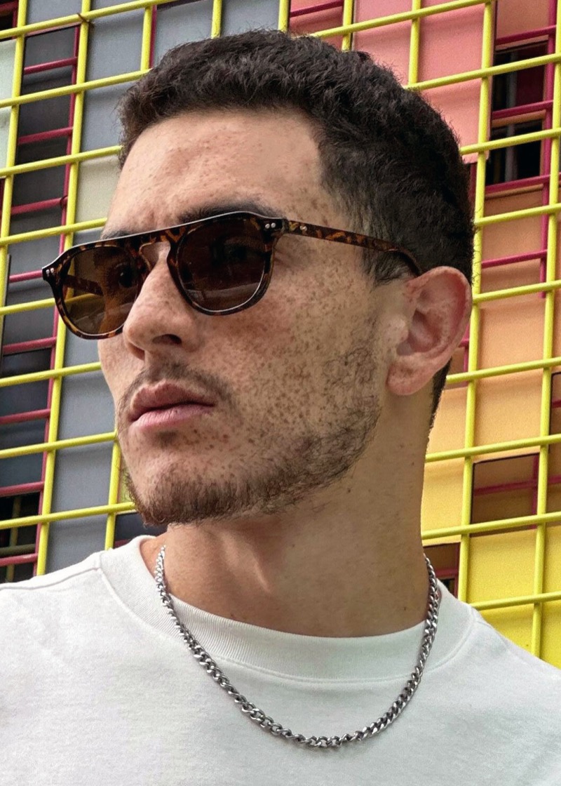 Man wearing round tortoiseshell sunglasses with brown-tinted lenses