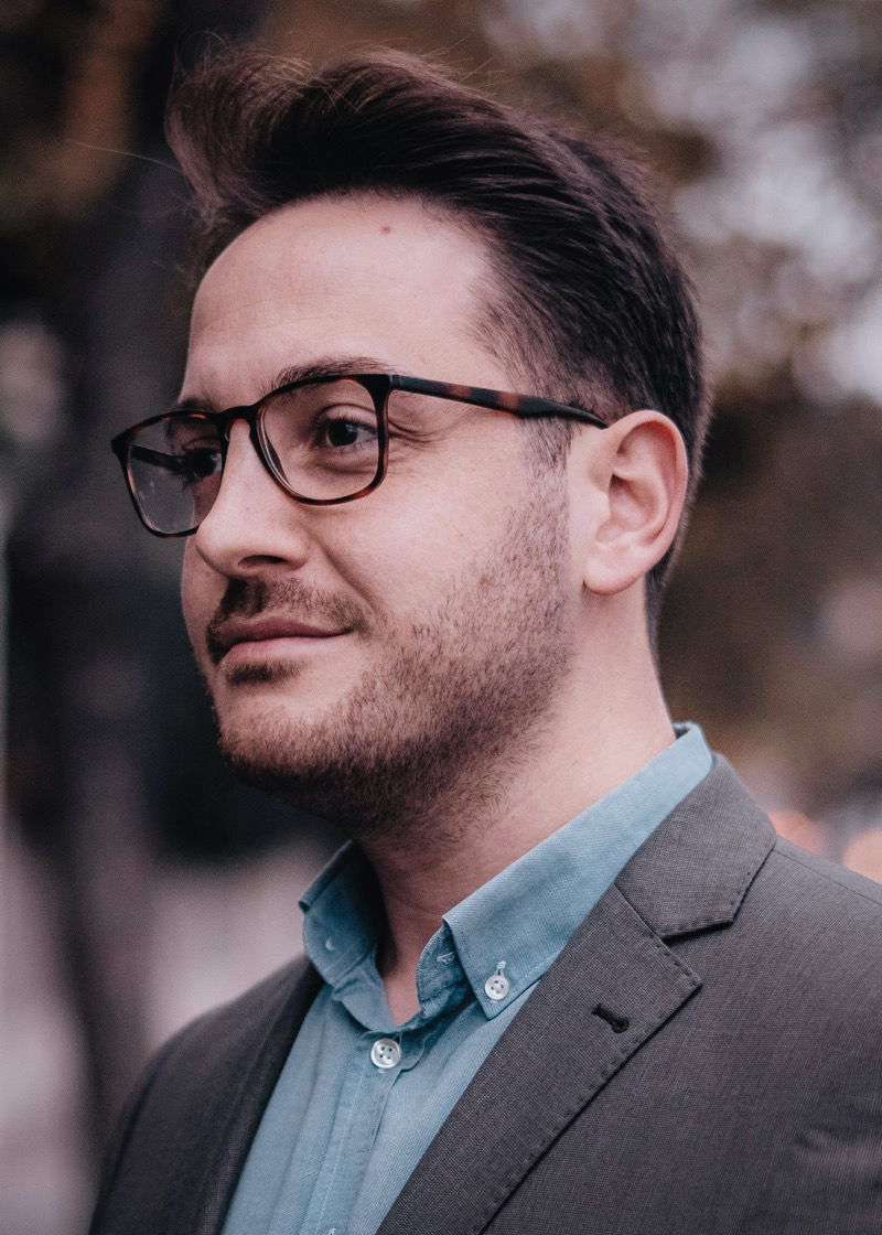 Man wearing square tortoiseshell glasses with a suit