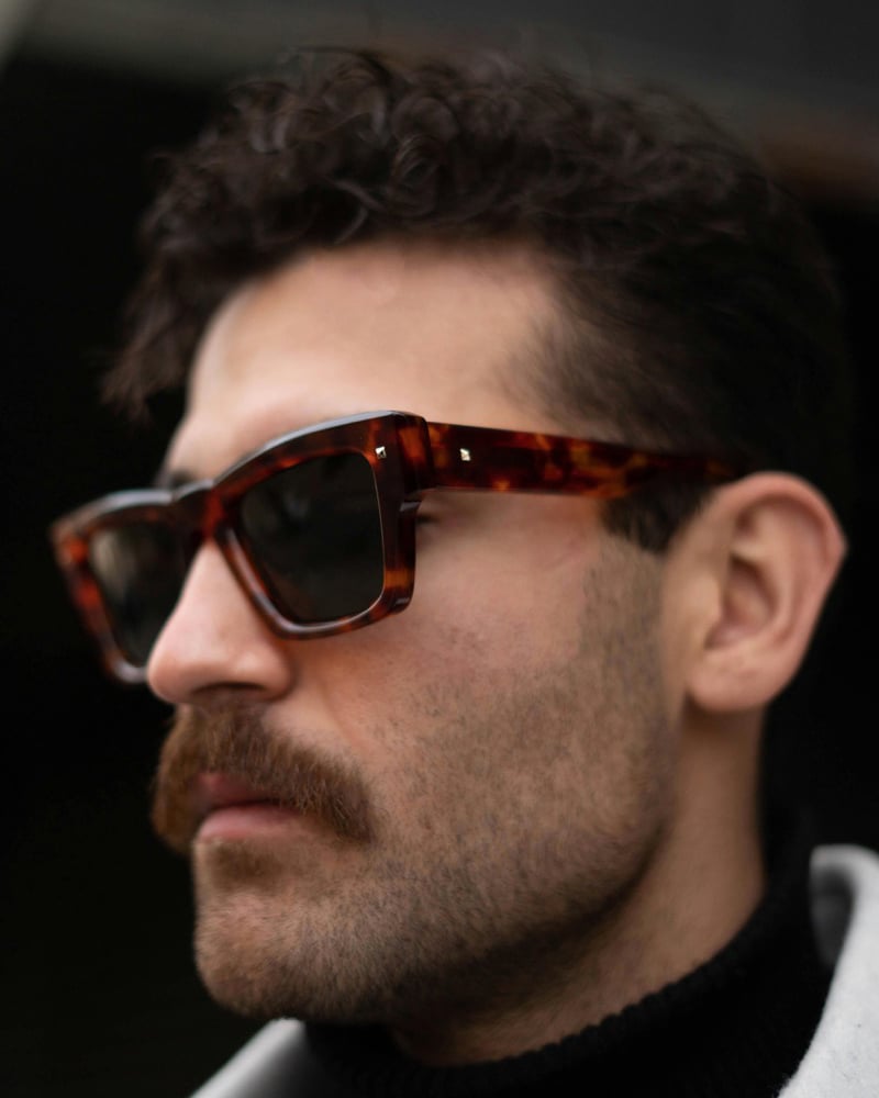 Man wearing square tortoiseshell sunglasses with thick acetate frames