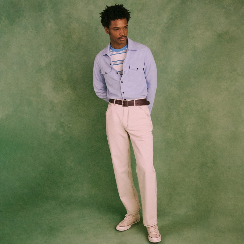 Model wears the Wallace & Barnes Carpenter Pant in off-white with a chambray workshirt and sneakers