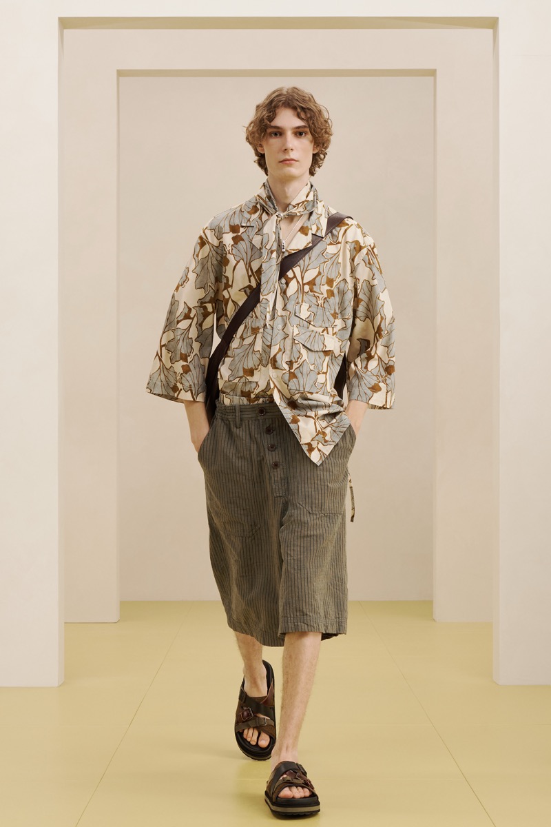 Zara SRPLS summer 2026 botanical-print camp shirt tucked into olive pinstripe pleated shorts with a leather crossbody bag and brown sandals