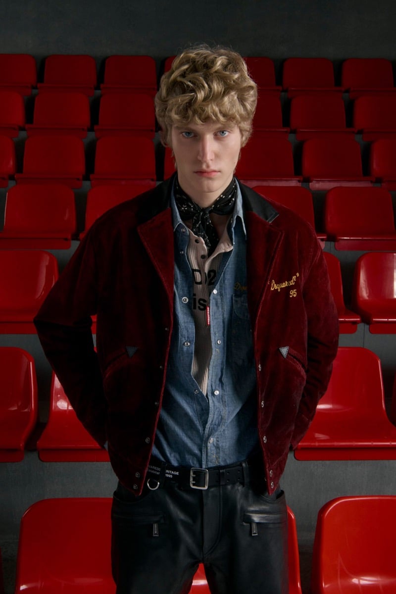 Kristaps Kallings wears a burgundy corduroy varsity jacket with black leather collar over a denim shirt and print shirt with a black bandana and black leather trousers