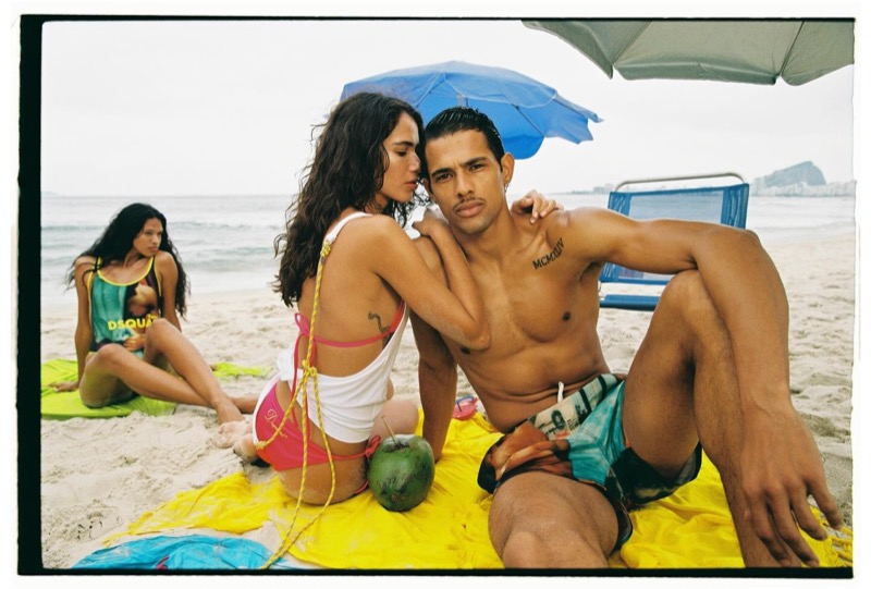 Jonas reclines on a yellow towel in printed Dsquared2 swim trunks