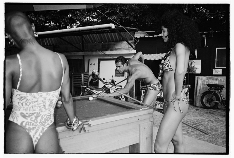 Models gathered around an outdoor pool table in Dsquared2 swimwear