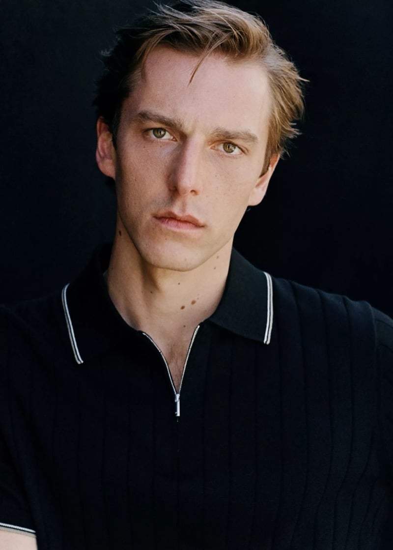 Close portrait of Quentin in a Mango black ribbed knit zip polo with a white tipped collar