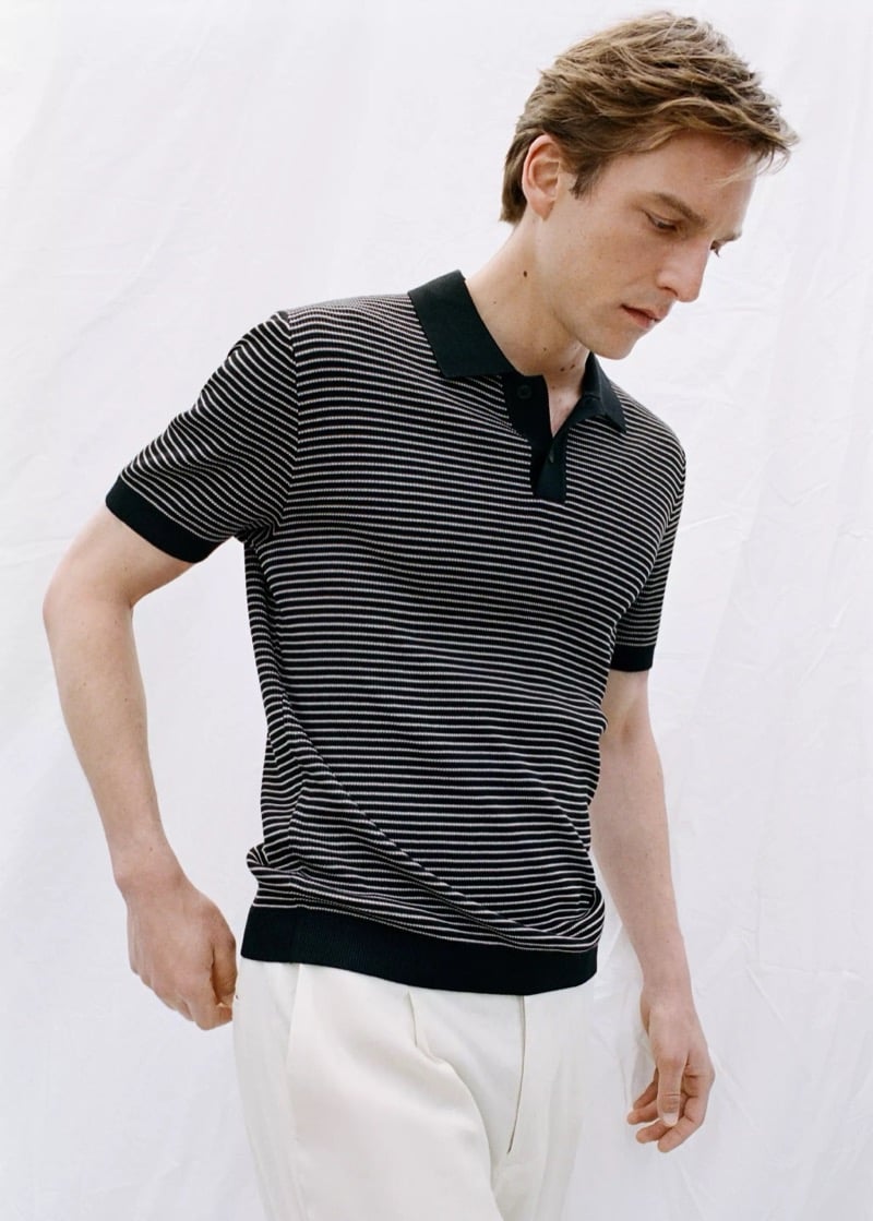 Quentin wears a Mango black and white striped short-sleeve knit polo with cream pleated trousers