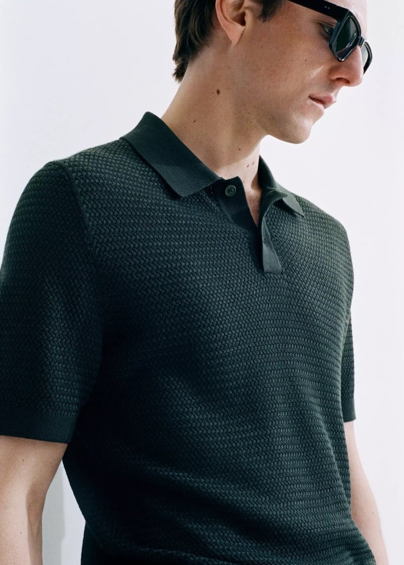 Quentin wears a Mango dark green textured knit polo with black sunglasses
