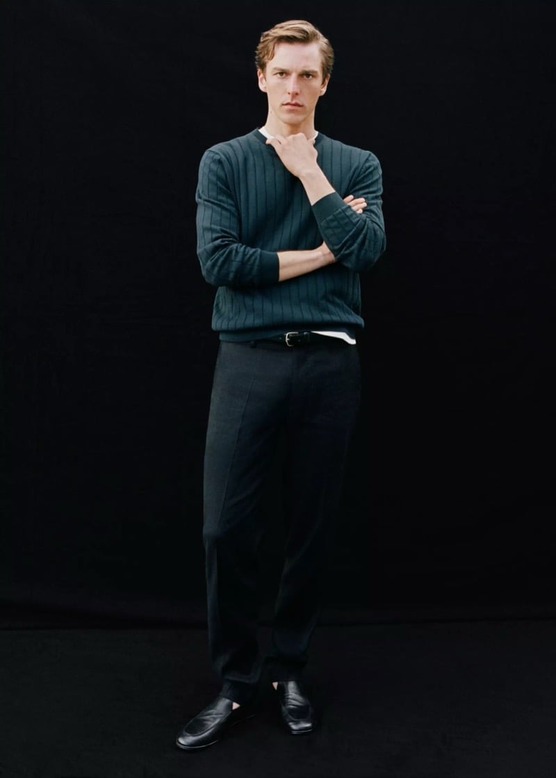 Quentin wears a Mango forest green ribbed knit pullover with black trousers and black leather loafers