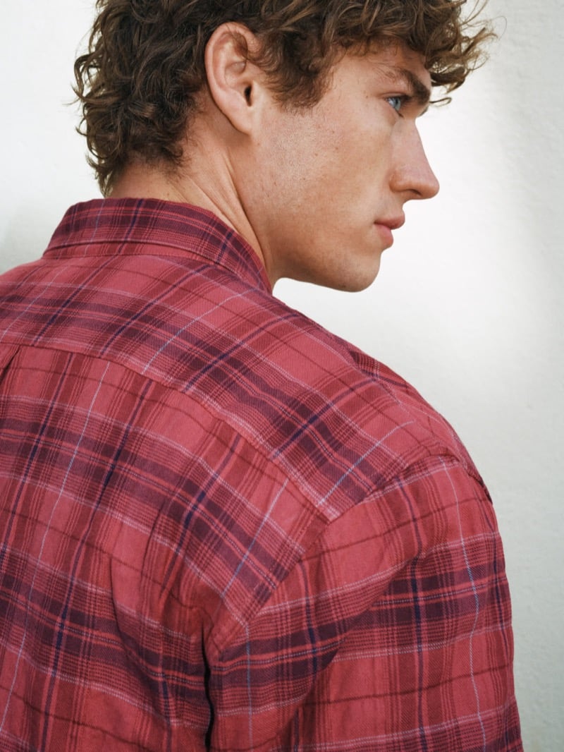 Detailed back and side view of Valentin Humbroich in a washed red plaid button-down shirt