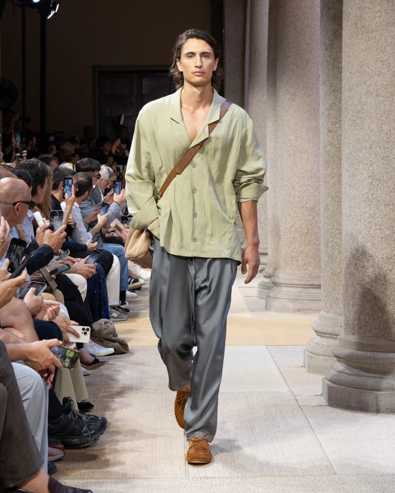 Model wears a soft camp-collar linen shirt with a draped fit, paired with wide pleated silk trousers