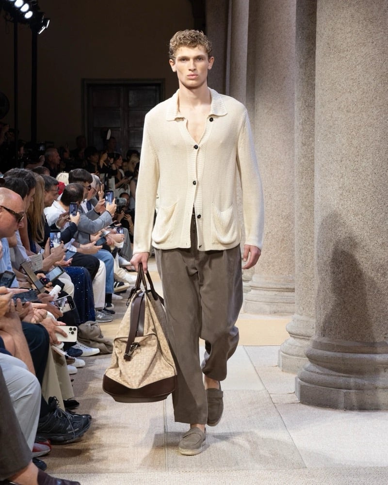 Model wears an open-knit camp-collar cardigan with patch pockets, paired with wide pleated drawstring linen trousers