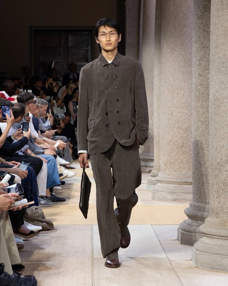 Model wears a double-breasted soft linen suit with a relaxed cut, layered over a tucked-in shirt