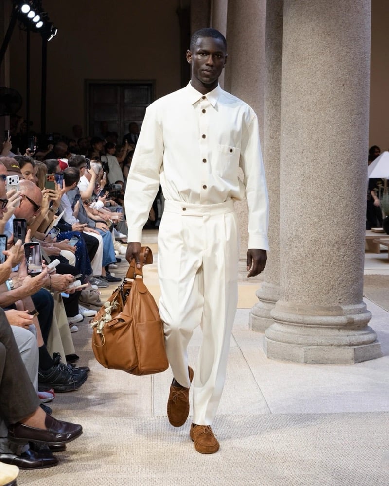 Model wears a long-sleeve linen overshirt with a chest patch pocket tucked into wide pleated linen trousers