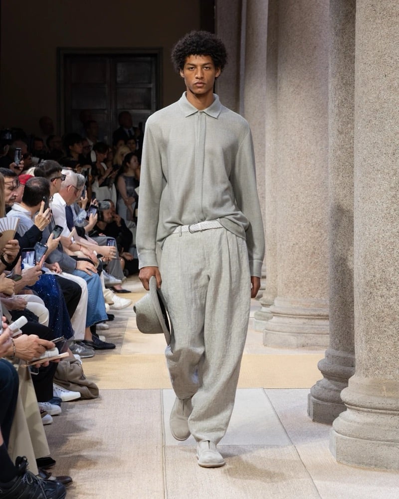 Model wears a long-sleeve fine-knit polo paired with wide pleated drawstring linen trousers