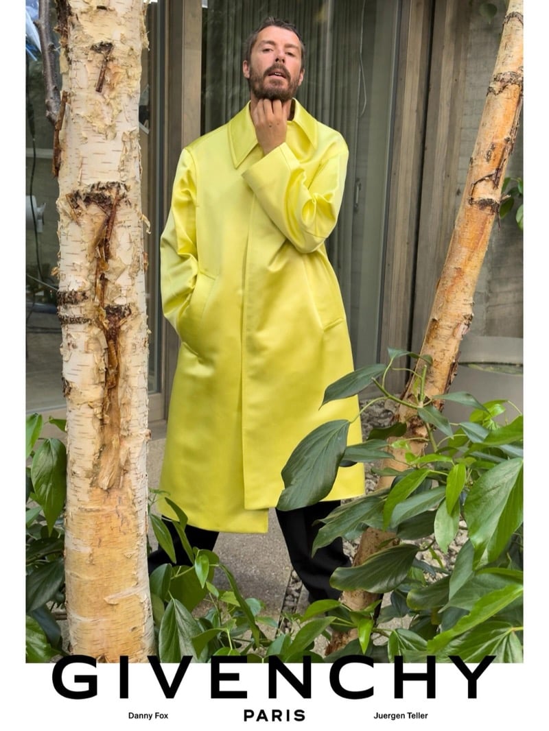 British painter Danny Fox stands among birch trees in a chartreuse Givenchy overcoat layered over dark trousers for the spring-summer 2027 campaign