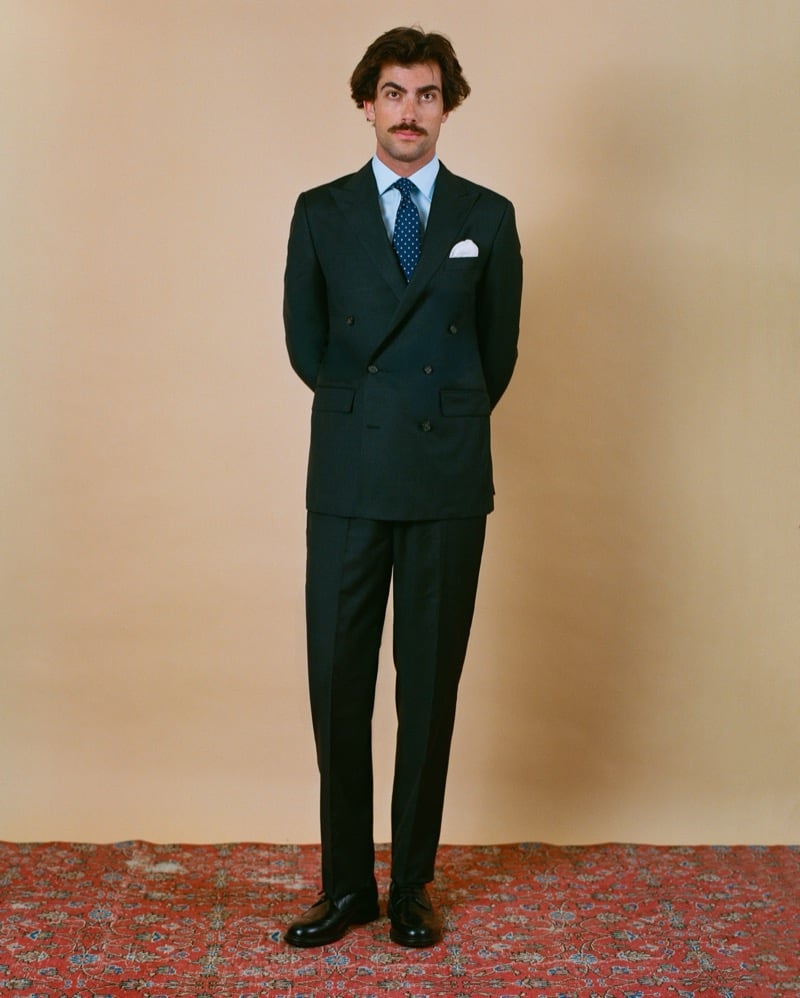 Victor Netland in the J. Press Mayfair double-breasted suit, paired with a dotted tie, a light blue dress shirt, and dark derby shoes