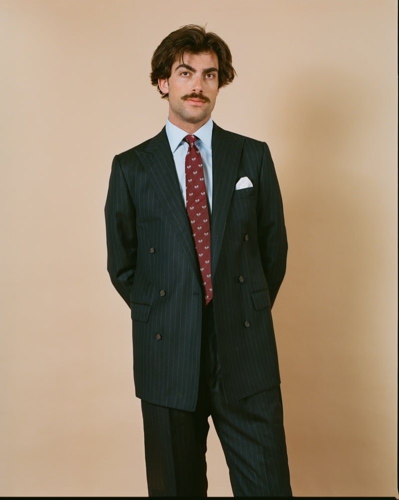 Victor Netland models the J. Press Mayfair double-breasted chalkstripe suit with a burgundy medallion-print tie, a light blue dress shirt, and a pocket square