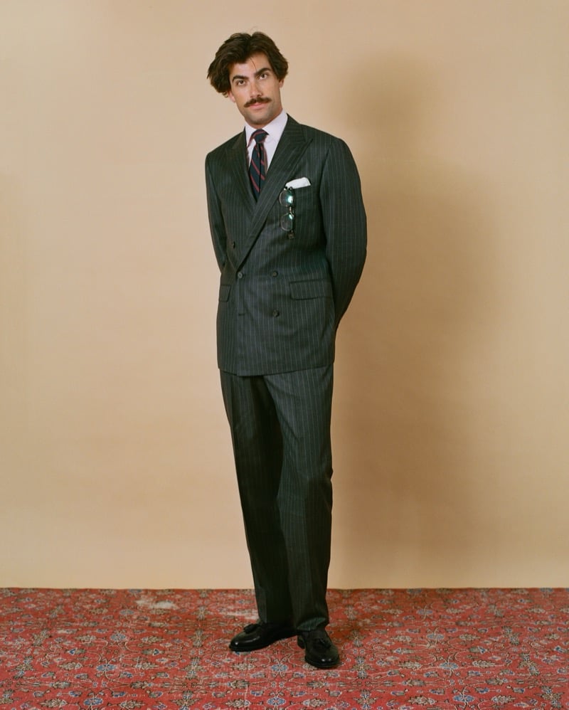 Victor Netland models the J. Press Mayfair double-breasted chalkstripe with a pink shirt and a striped repp tie, sunglasses tucked into the pocket square
