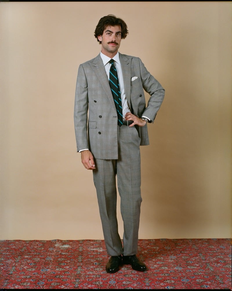 Victor Netland models the J. Press Mayfair double-breasted suit in light gray Prince of Wales check, paired with a dark striped repp tie and a dress shirt
