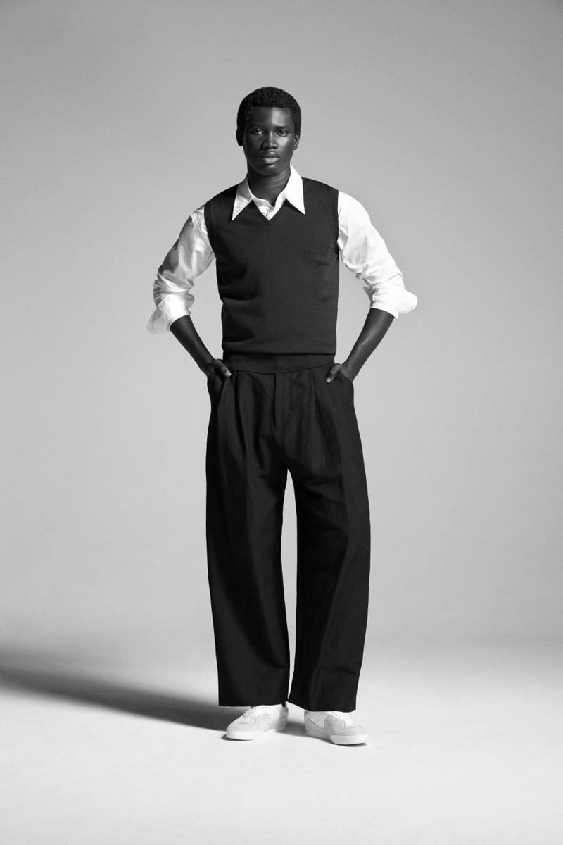 Alexander Acquah in the John Smedley Hadfield extra fine merino slipover, layered over a poplin shirt with wide-leg pleated trousers and sneakers