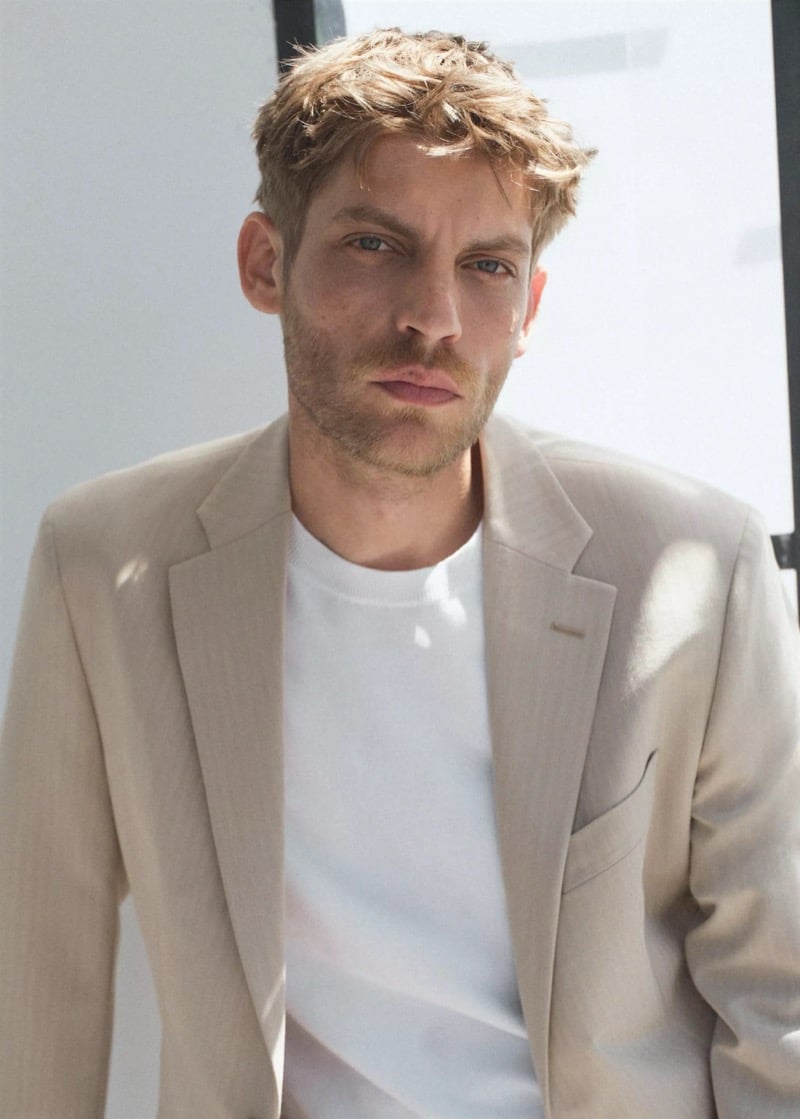 Close-up of Baptiste Radufe in a beige tailored blazer worn over a white crew neck T-shirt for Mango Man summer 2026
