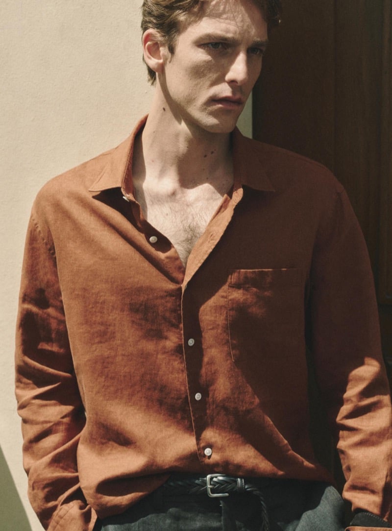 Quentin Demeester in a Massimo Dutti open-collar linen shirt with a braided leather belt