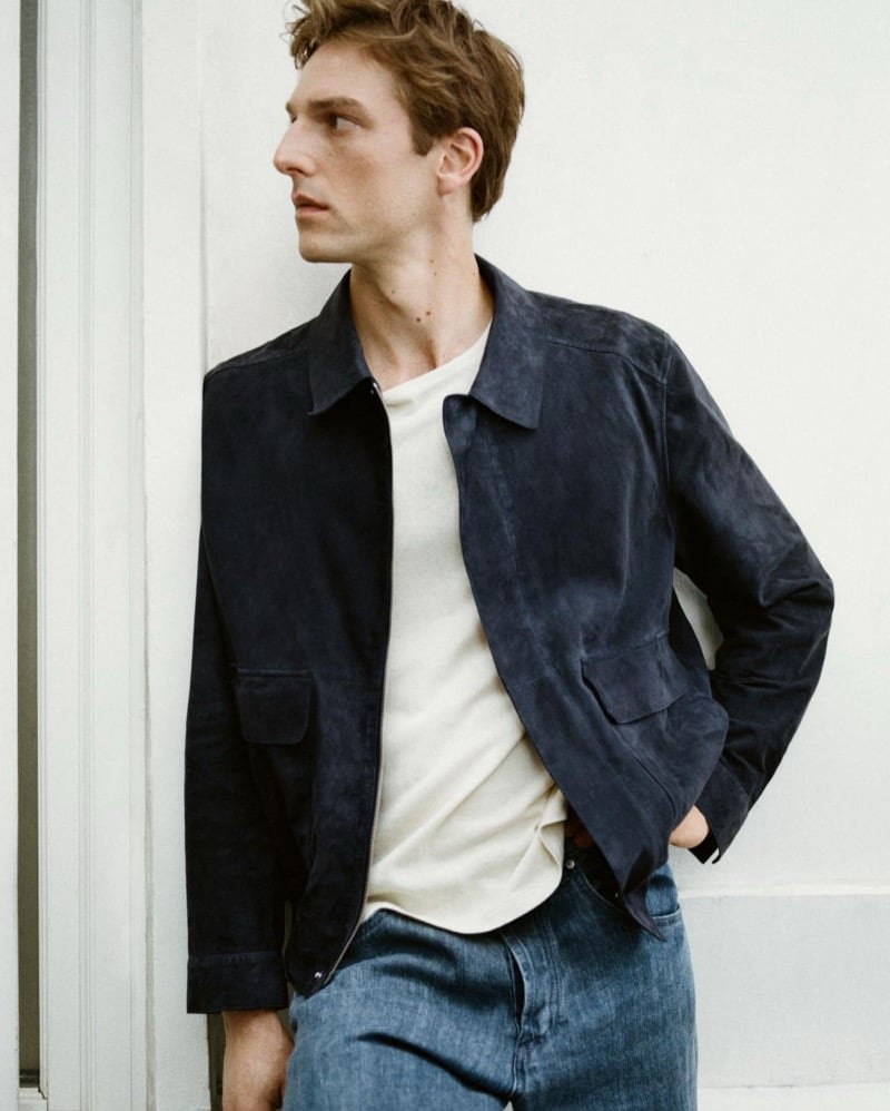 Quentin Demeester against a paneled wall in a Massimo Dutti suede blouson over a knit tee with washed straight-leg jeans