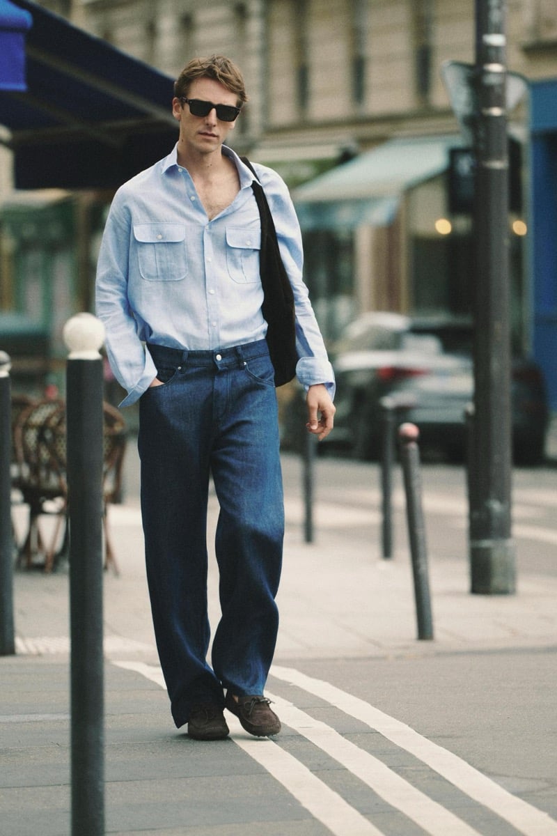 Quentin Demeester walking past a Paris cafe in Massimo Dutti rectangular sunglasses, a button-down shirt, wide-leg denim, and suede moccasins