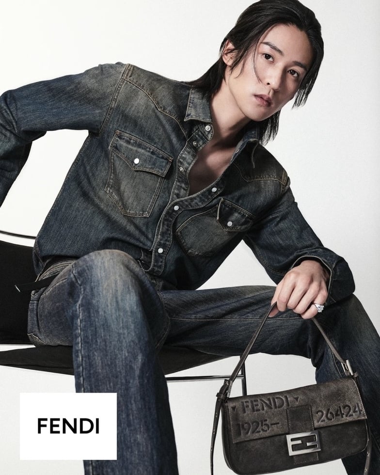 Ren Meguro seated in a worn indigo denim western shirt and matching jeans, holding the Fendi Baguette 26424 in embossed suede with silver FF clasp