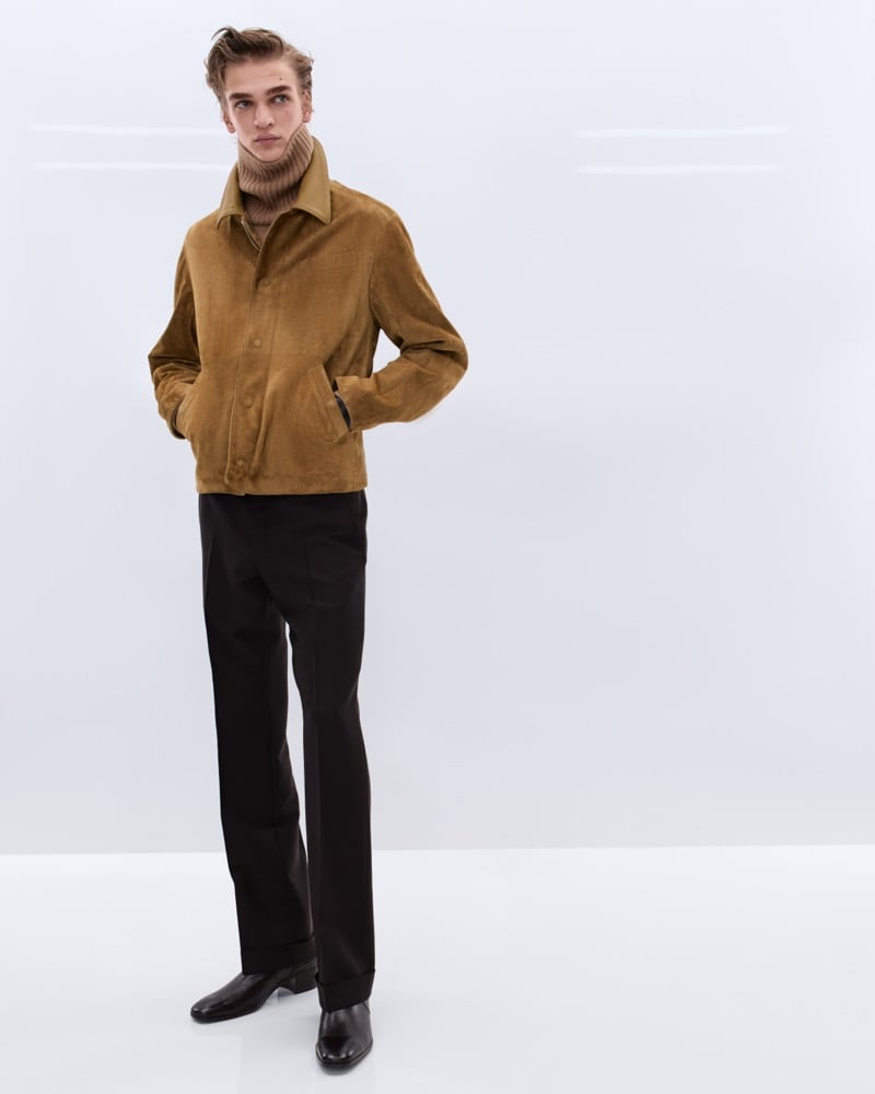 Dario Tonin wears a tobacco corduroy shirt jacket over a tan ribbed turtleneck with brown wool trousers and brown leather Chelsea boots